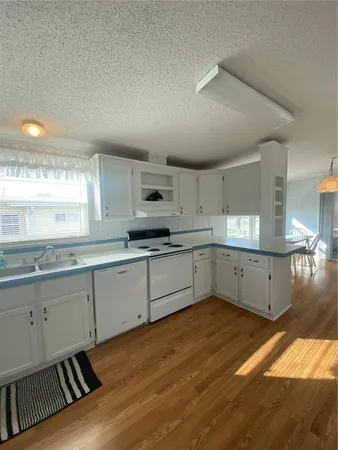 a kitchen with granite countertop white cabinets and white appliances