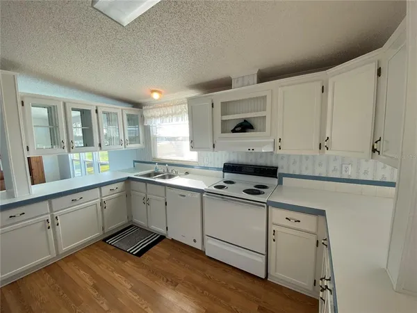 a kitchen with granite countertop a sink cabinets and wooden floor