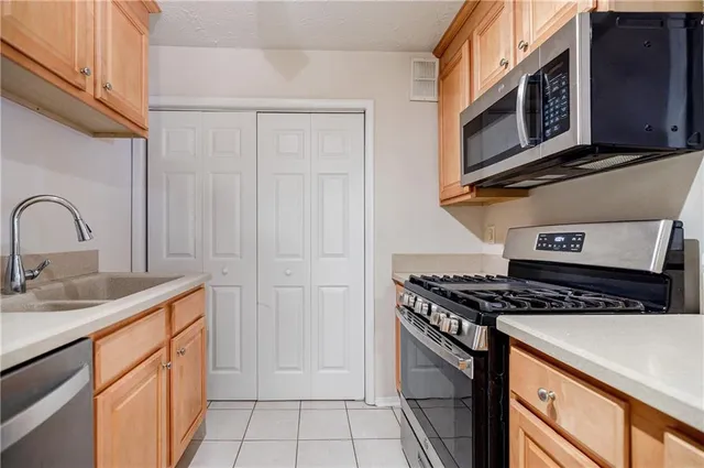 a kitchen with stainless steel appliances granite countertop a sink stove and cabinets