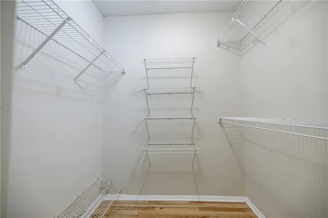 a view of walk in closet with empty racks