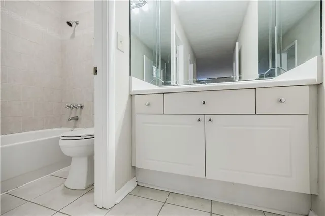 a bathroom with a granite countertop toilet and a sink