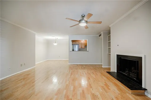 a view of empty room with wooden floor and fireplace