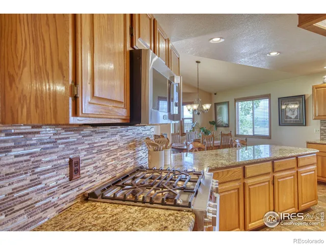 a kitchen with stainless steel appliances granite countertop a sink stove and cabinets