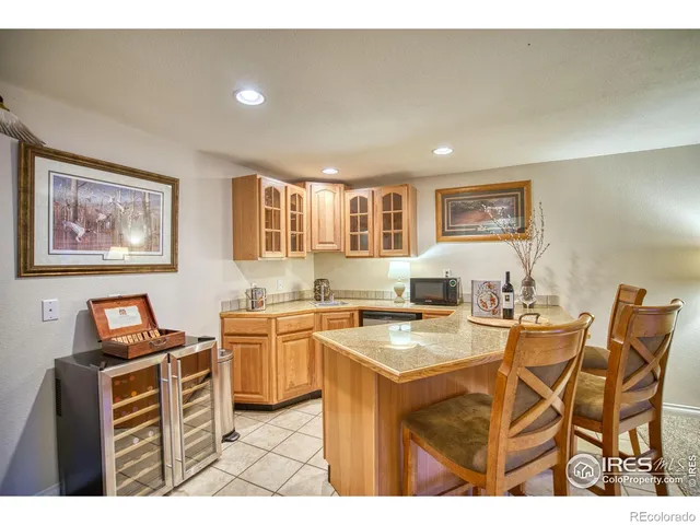 a open kitchen with stainless steel appliances kitchen island granite countertop a stove top oven a sink a dining table and chairs with wooden floor