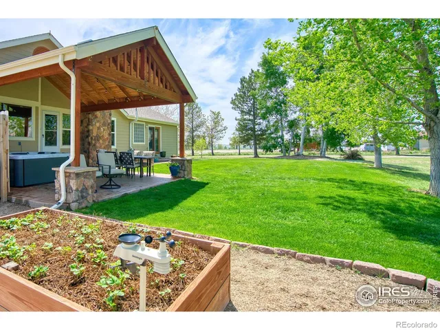 a view of a chair and table in backyard of the house