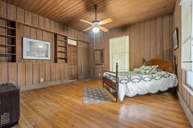 a spacious bedroom with a bed and wooden floor