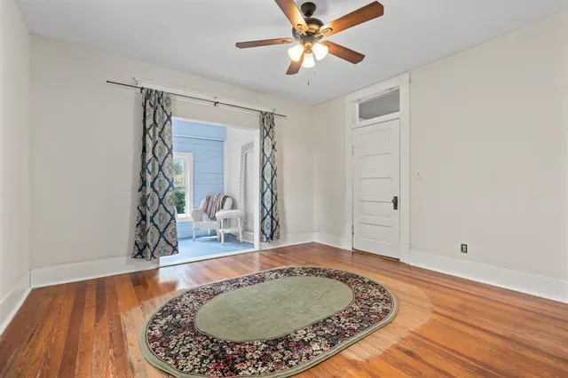 a view of a livingroom with wooden floor and a ceiling fan