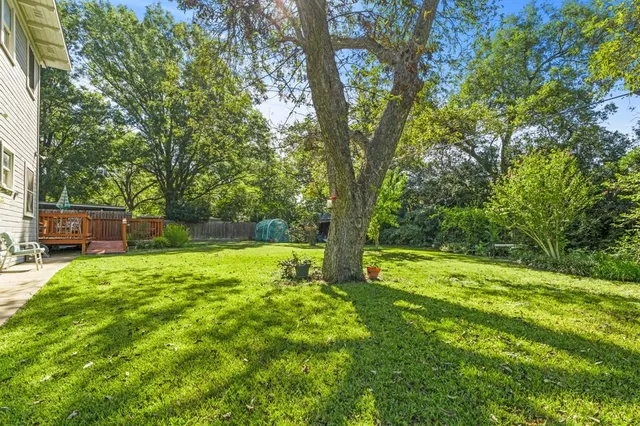 a view of backyard with table and chairs and wooden fence