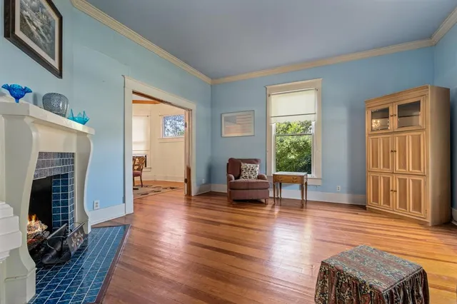 a living room with furniture a fireplace and wooden floor