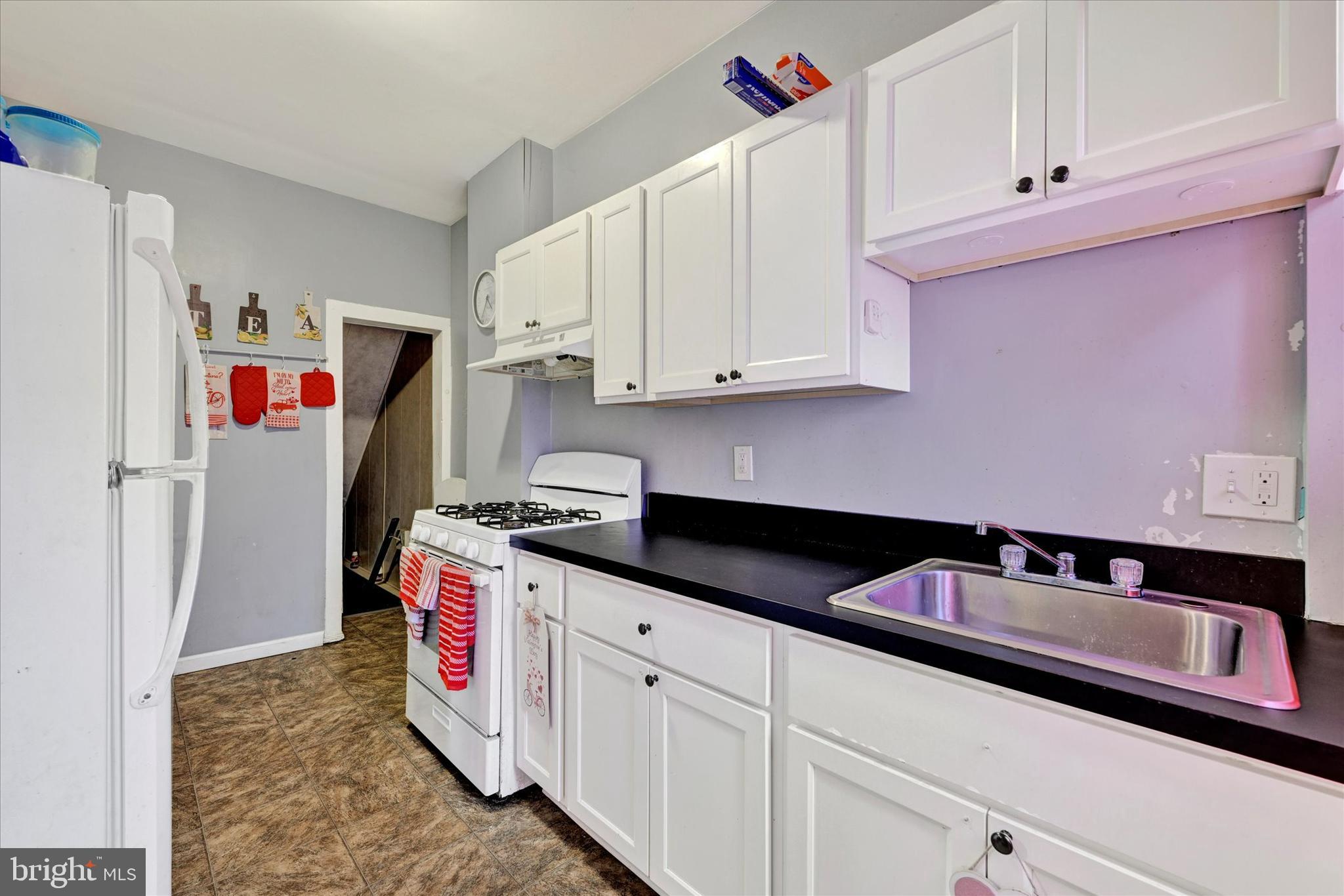 3117 Baker Street Baltimore, MD 21216 - Photo 5 of 17 a kitchen with granite countertop white cabinets and stainless steel appliances