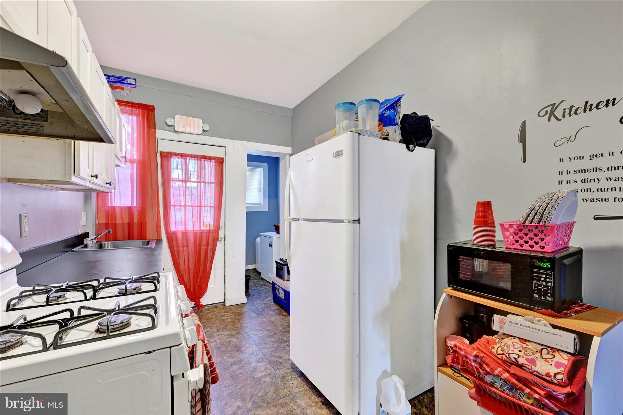 3117 Baker Street Baltimore, MD 21216 - Photo 6 of 17 a kitchen with stainless steel appliances granite countertop a refrigerator and a stove