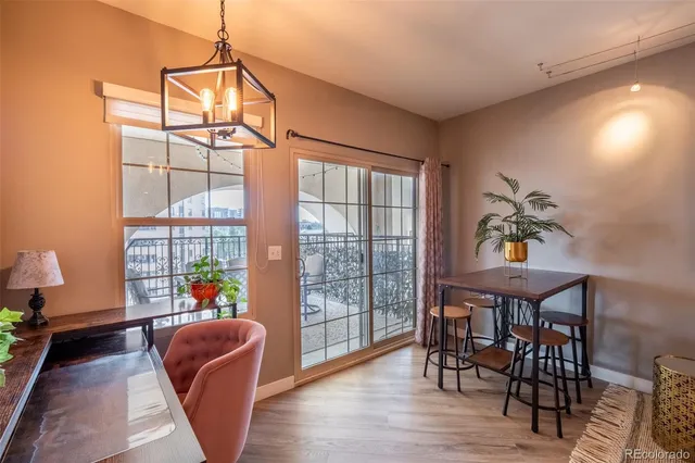 a dining room with furniture a chandelier and wooden floor