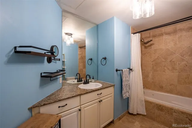 a bathroom with a granite countertop sink a mirror and a bathtub
