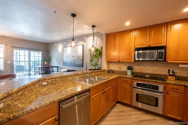 a kitchen with stainless steel appliances granite countertop a sink and stove top oven