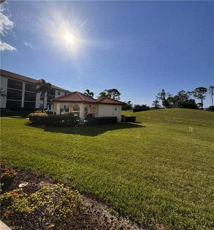 605 Augusta Boulevard, Unit 4 Naples, FL 34113 - Photo 12 of 14 a view of a large pool with lawn chairs and a big yard