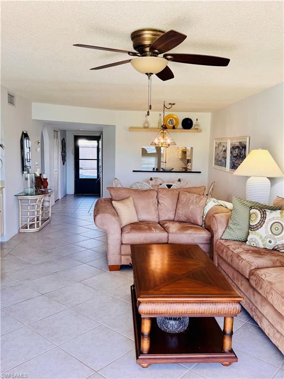 605 Augusta Boulevard, Unit 4 Naples, FL 34113 - Photo 3 of 14 a living room with furniture and a chandelier