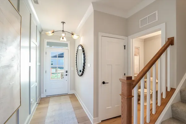 a view of a hallway with wooden floor and staircase