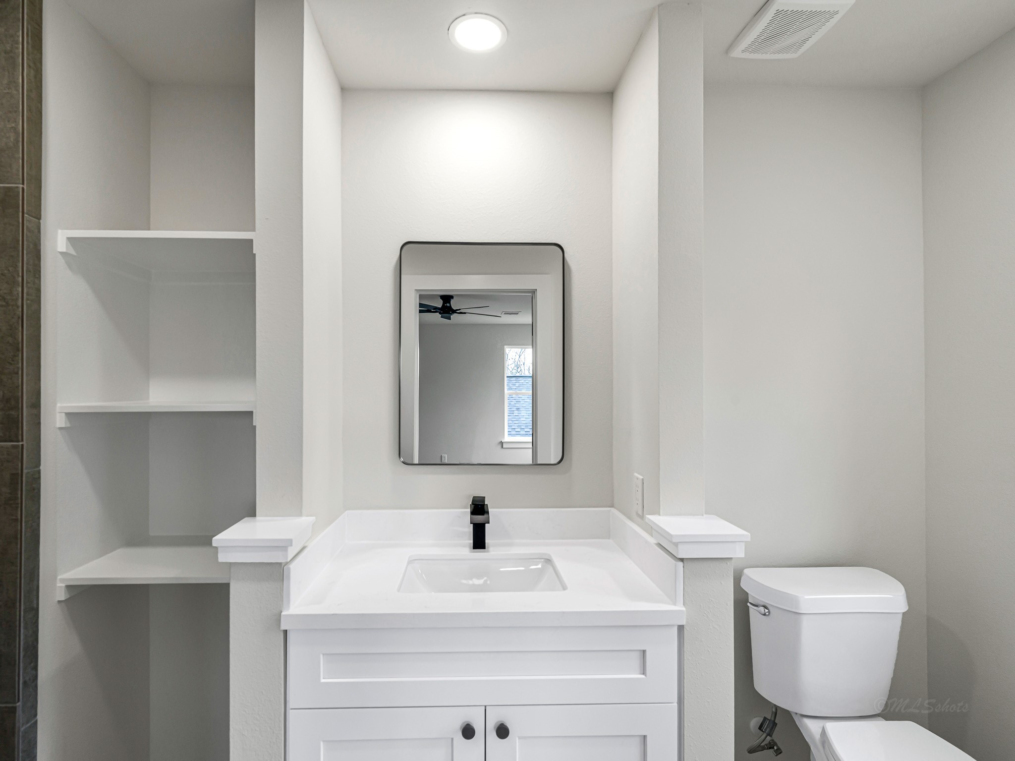 1006 4th Street Hempstead, TX 77445 - Photo 24 of 29 a bathroom with a toilet sink vanity and mirror
