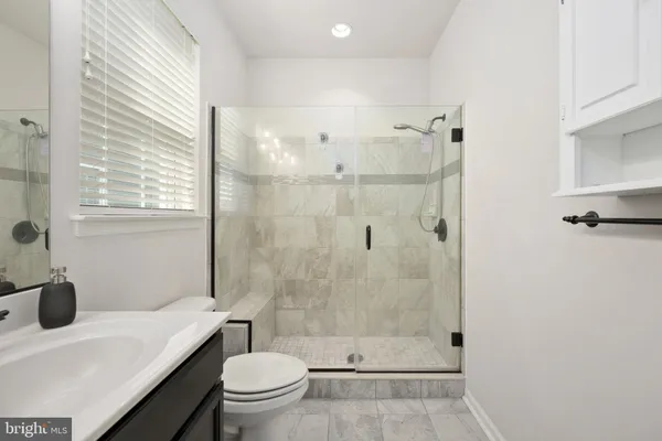 a bathroom with a sink a toilet and shower