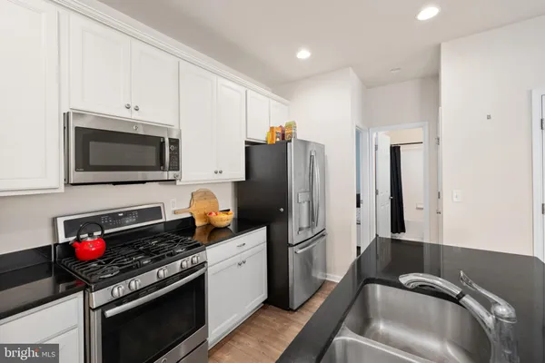 a kitchen with stainless steel appliances granite countertop a stove a sink and a refrigerator