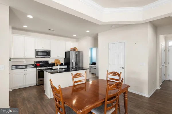 a kitchen with refrigerator and wooden floor