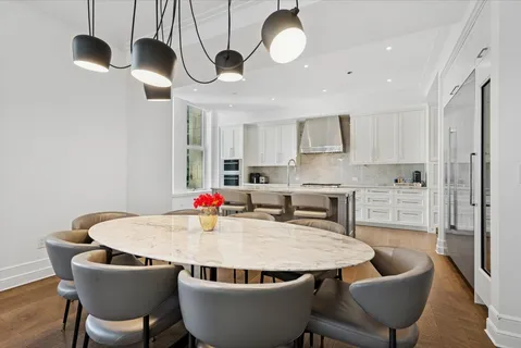 a kitchen with stainless steel appliances granite countertop a kitchen island a stove a table and chairs