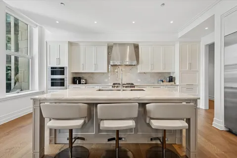 a kitchen with stainless steel appliances granite countertop a sink and a refrigerator