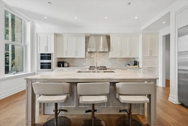 a kitchen with stainless steel appliances granite countertop a sink and a refrigerator