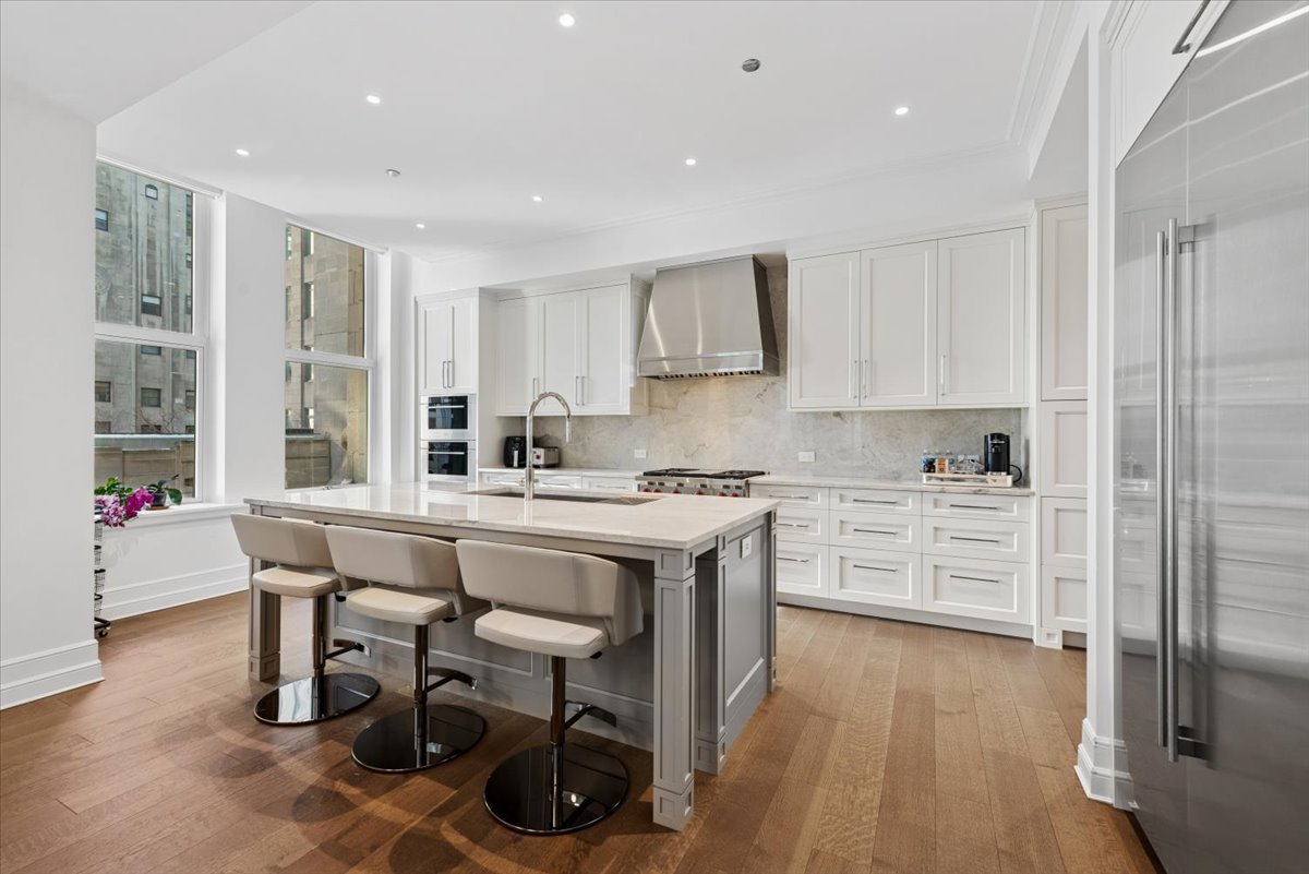 435 North Michigan Avenue, Unit 503 Chicago, IL 60611 - Photo 15 of 48 a kitchen with stainless steel appliances kitchen island granite countertop a stove a sink a refrigerator and white cabinets with wooden floor