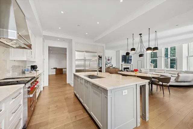 a large kitchen with stainless steel appliances a stove and a refrigerator