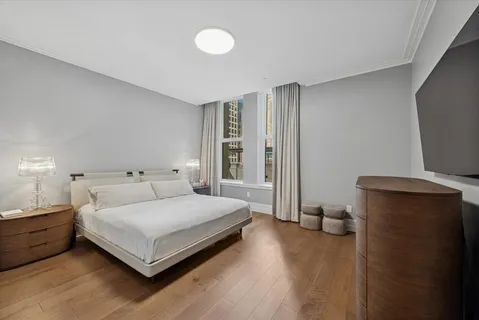 a bedroom with a bed and large windows