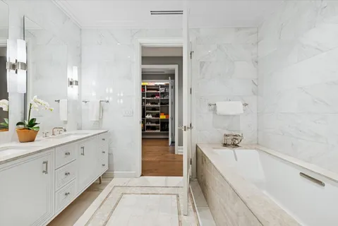 a spacious bathroom with a tub sink and mirror