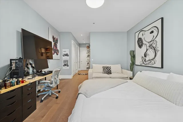 a bedroom with a bed and a flat tv screen on the dresser