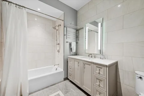 a bathroom with a granite countertop sink a toilet and shower