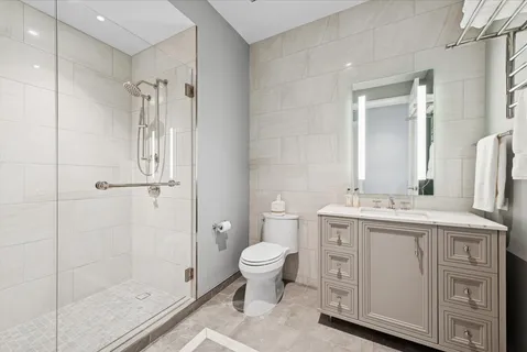 a bathroom with a granite countertop sink a toilet and shower