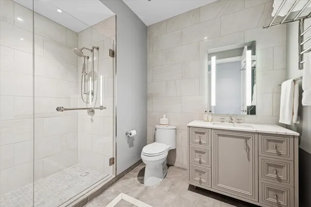 a bathroom with a granite countertop sink a toilet and shower