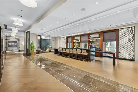 a view of a hall with floor to ceiling windows and dining room