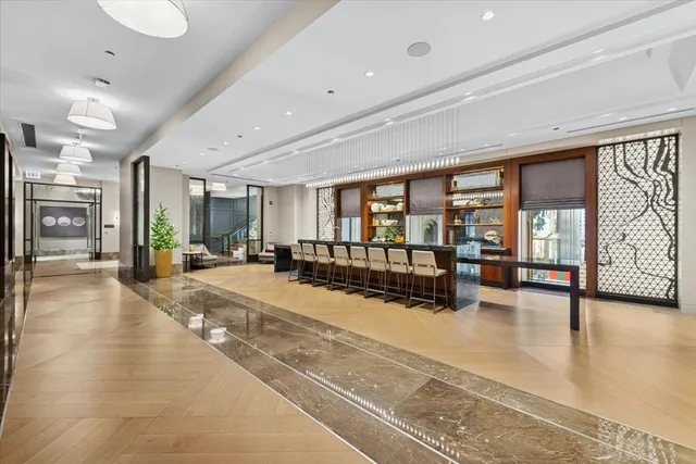 a view of a hall with floor to ceiling windows and dining room