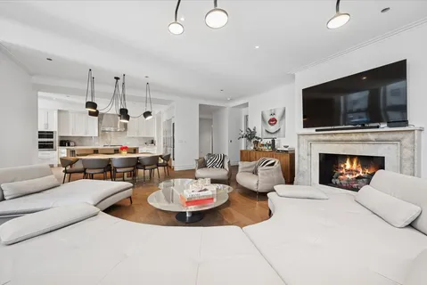 a living room with furniture kitchen view and a fireplace