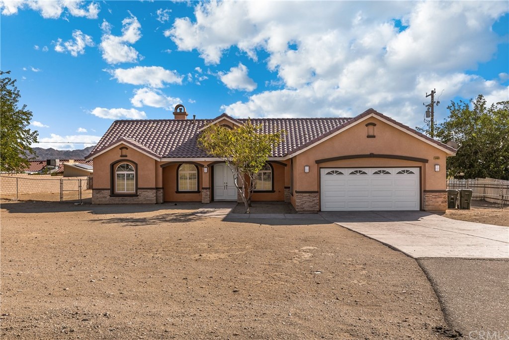 16409 Rancherias Road Apple Valley, CA 92307 - Photo 1 of 1 a front view of a house with a yard and garage