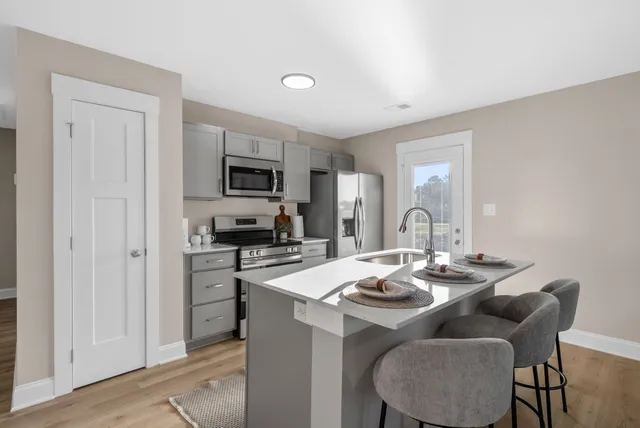 a kitchen with a dining table chairs and refrigerator