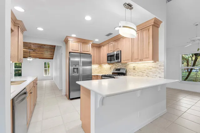 a kitchen with granite countertop a stove top oven microwave and cabinets