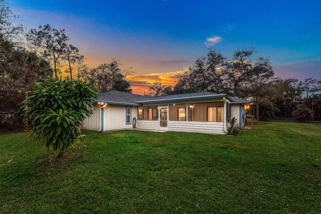 a view of a big yard with plants and large trees