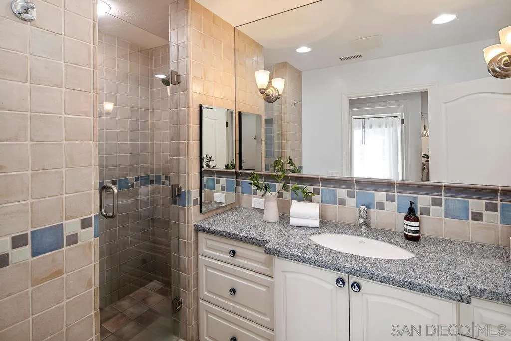 6117 La Flecha Rancho Santa Fe, CA 92067 - Photo 29 of 37 a bathroom with a granite countertop sink a mirror and a shower