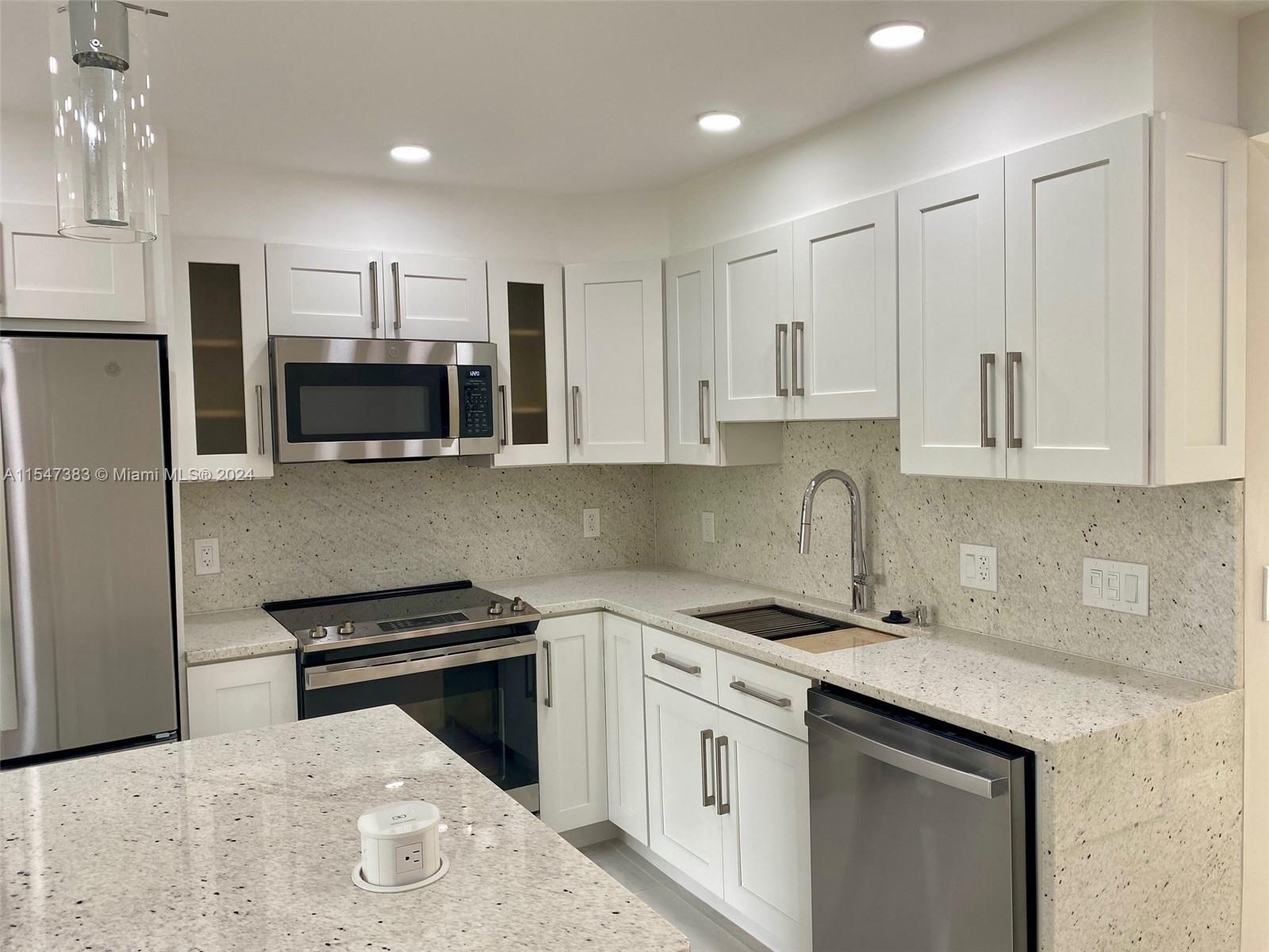 a kitchen with stainless steel appliances kitchen island a white cabinets sink and stove