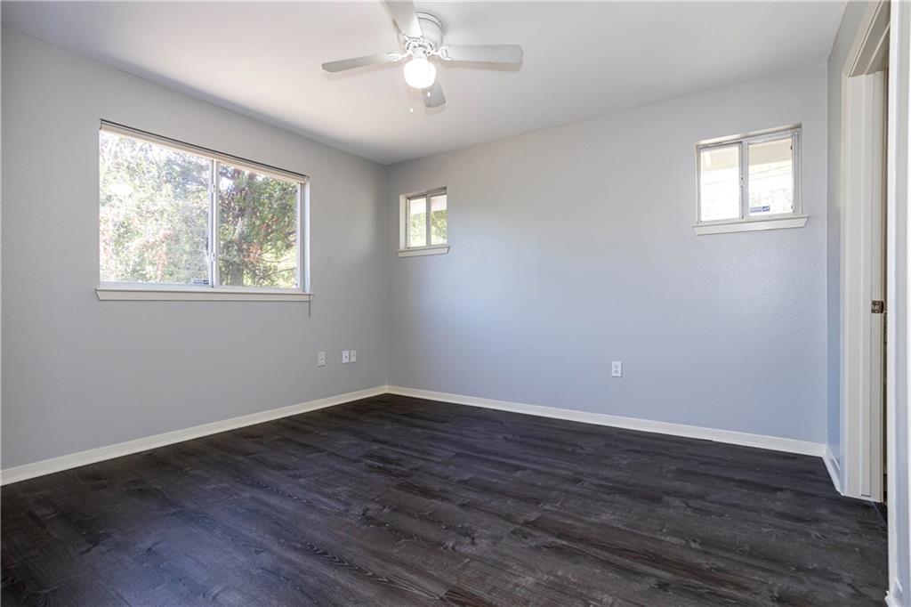 1326 Delano Street Austin, TX 78721 - Photo 14 of 23 Unfurnished room featuring dark wood-style flooring and a ceiling fan