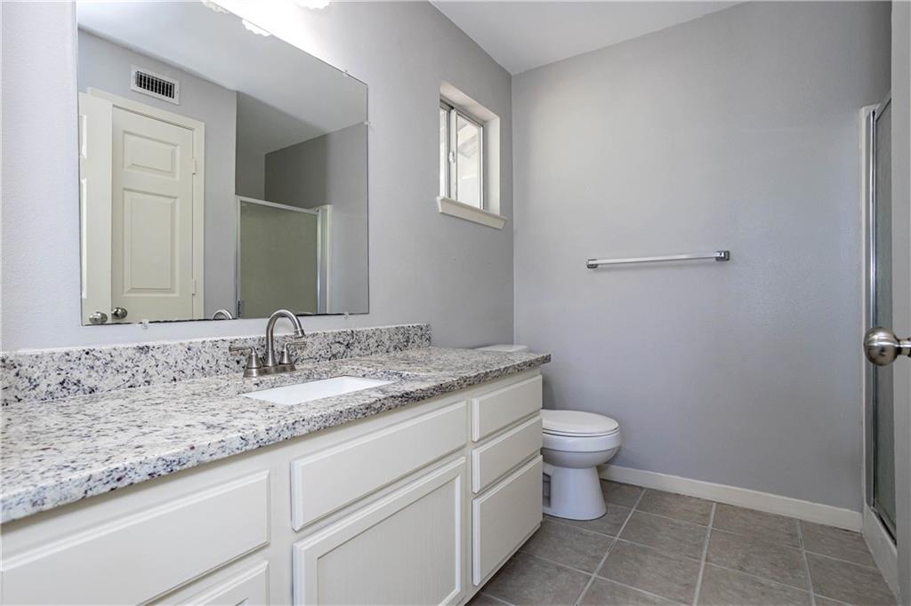 1326 Delano Street Austin, TX 78721 - Photo 15 of 23 Bathroom with a shower stall, vanity, and light tile patterned flooring