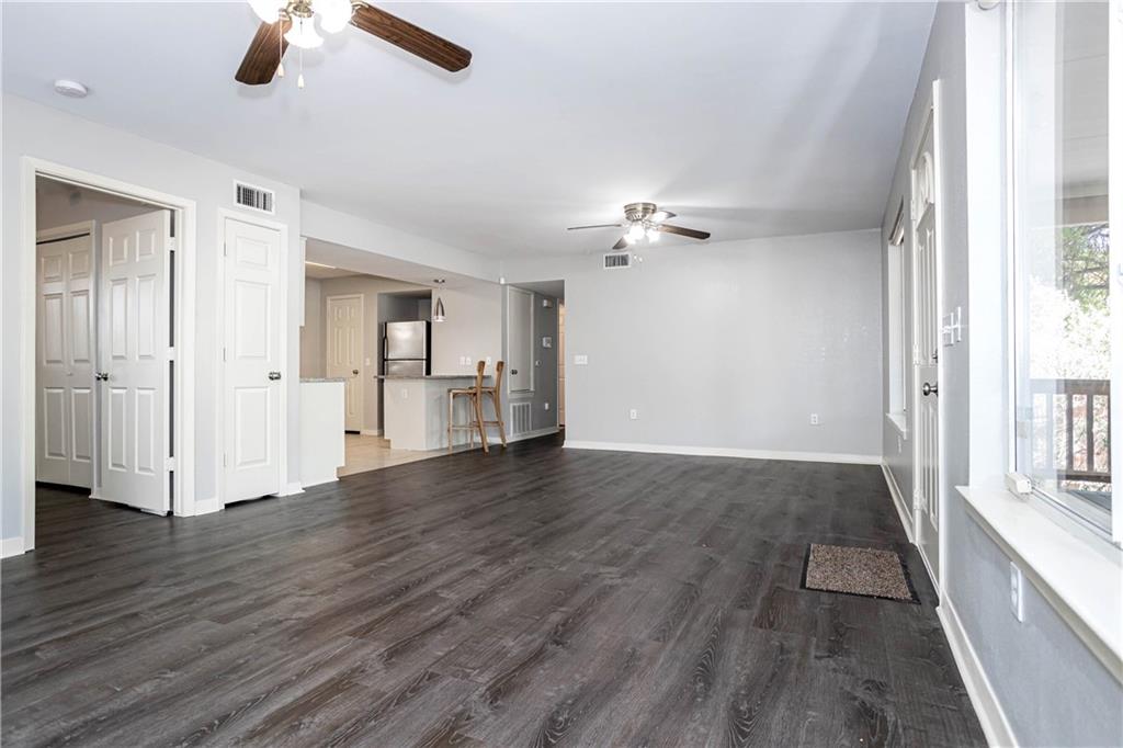 1326 Delano Street Austin, TX 78721 - Photo 10 of 23 Unfurnished living room with ceiling fan and dark wood-style flooring