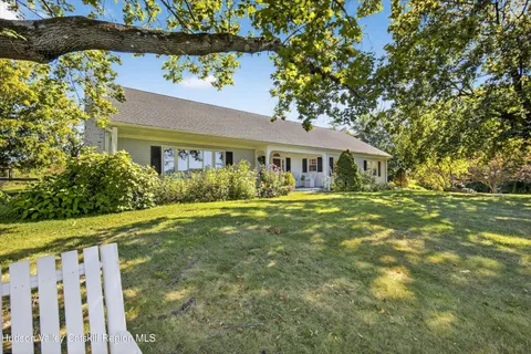 an aerial view of a house with garden space and mountain view in back