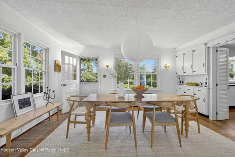 a view of a swimming pool with lawn chairs and a big yard